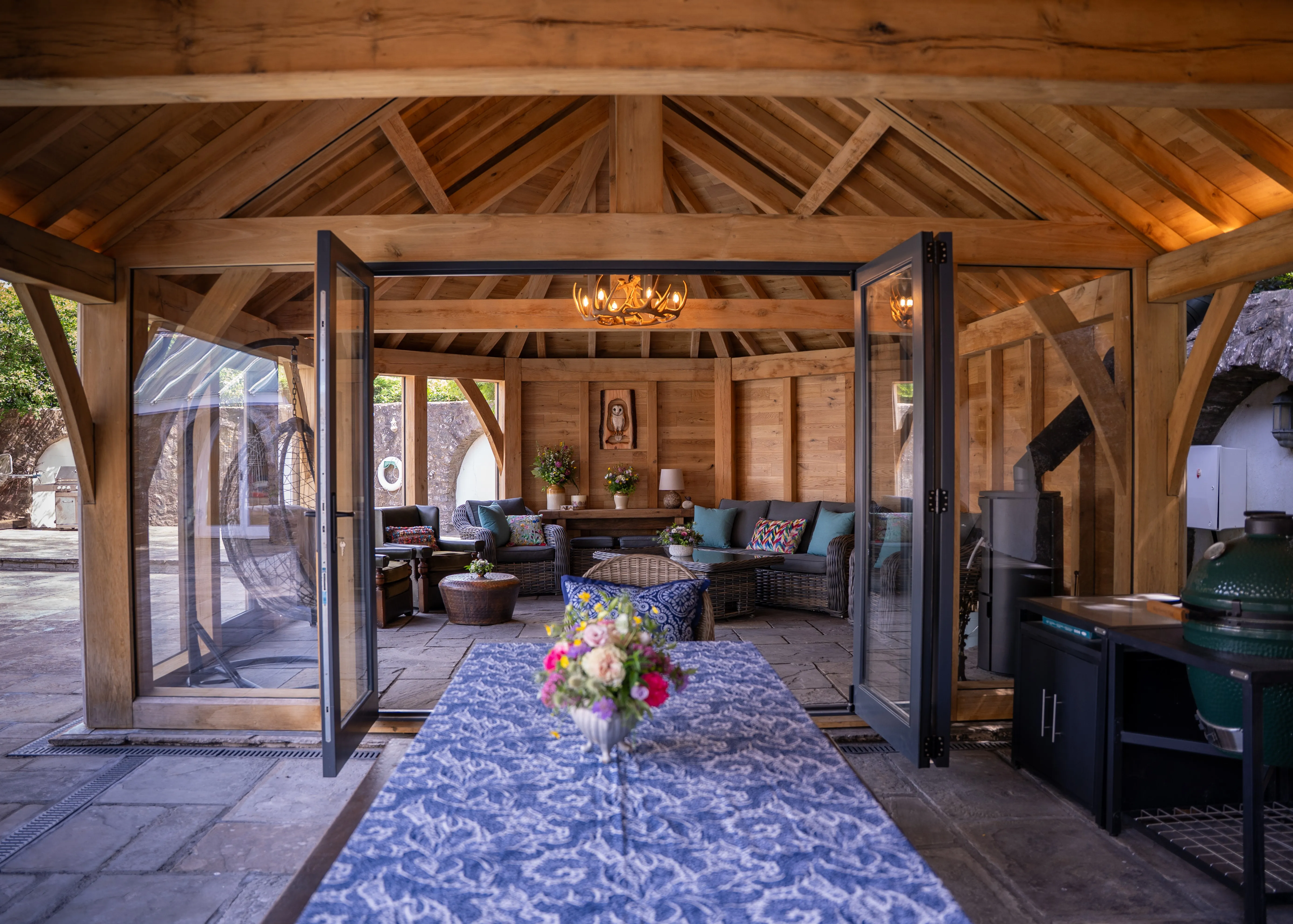 Oak frame garden room with exposed trusses and open bi-fold doors, Monmouthshire