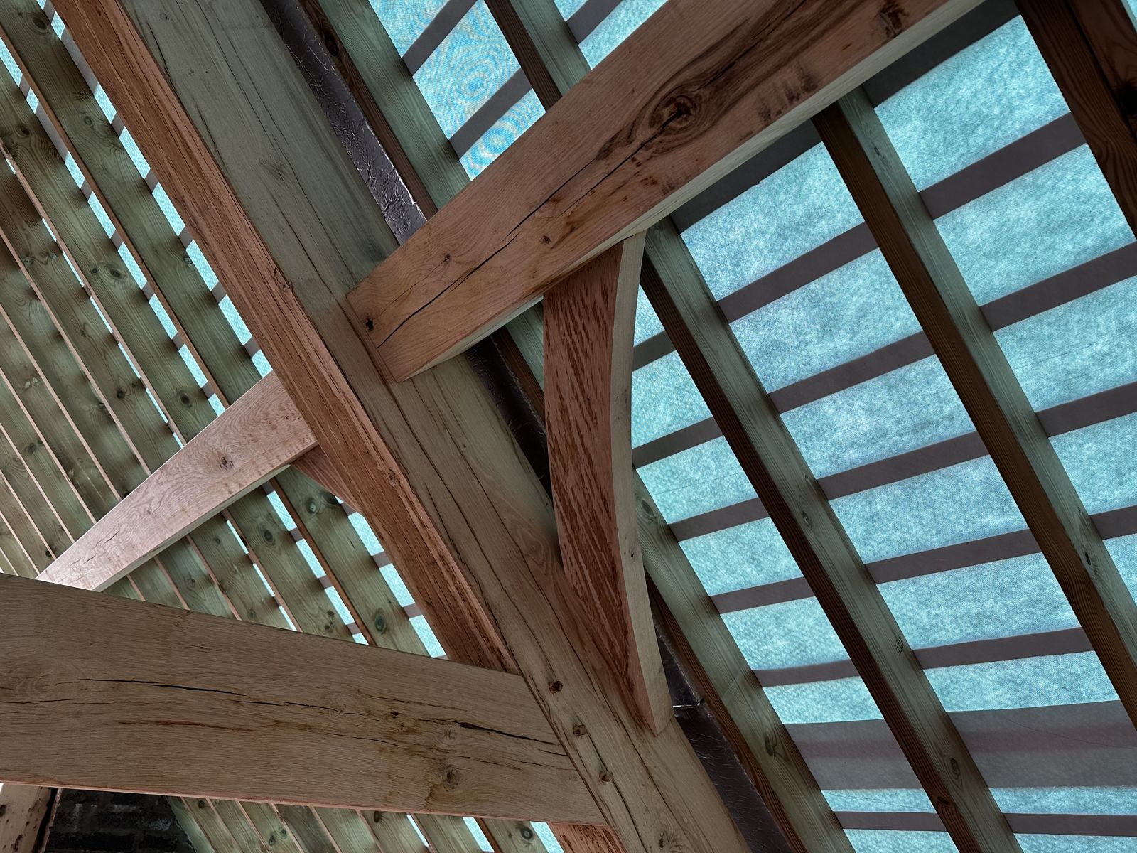 Close-up of an oak roof joint with a curved brace, pegged, in the barn next to the workshop