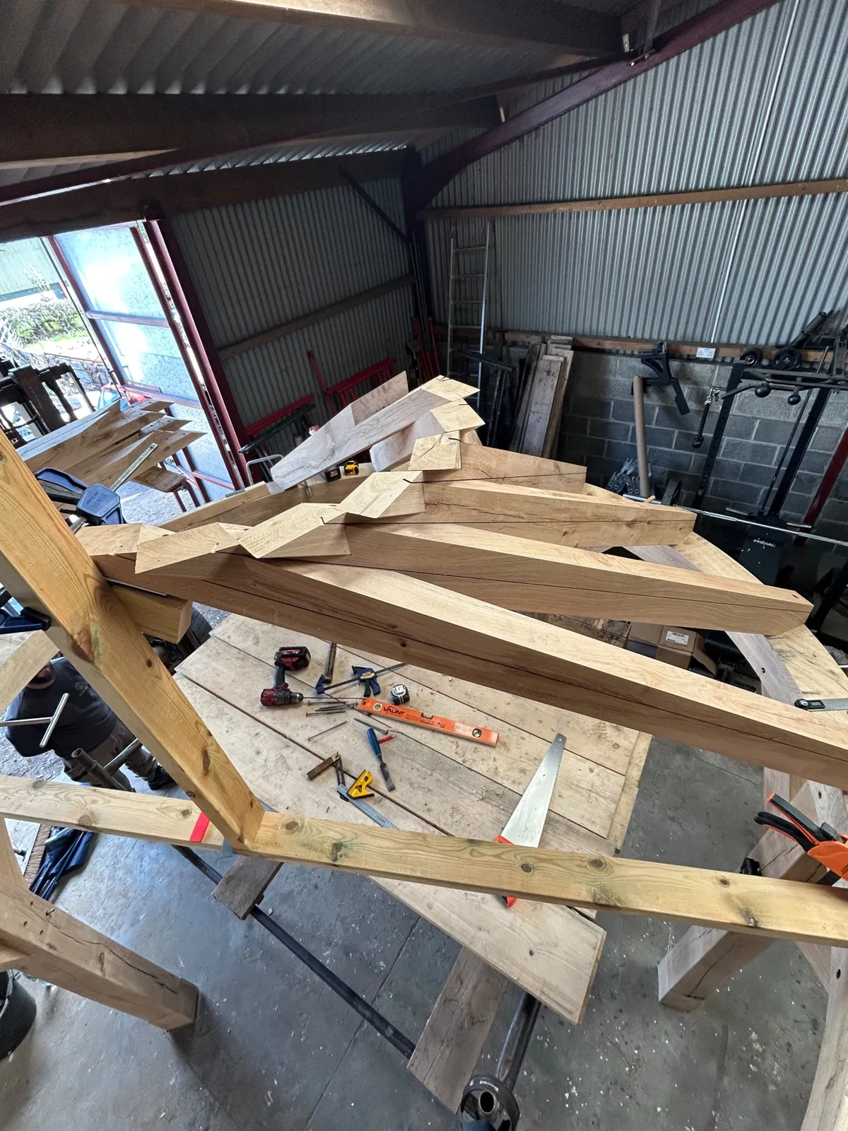 Pegged joint holes drilled through an oak post and curved brace in the workshop