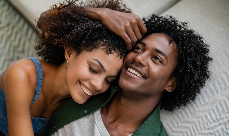 Happy couple embracing and smiling together, representing intimacy and relationship wellness