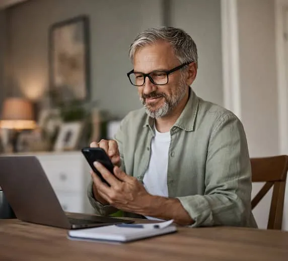 Man using a smartphone to access personalized telehealth care from home