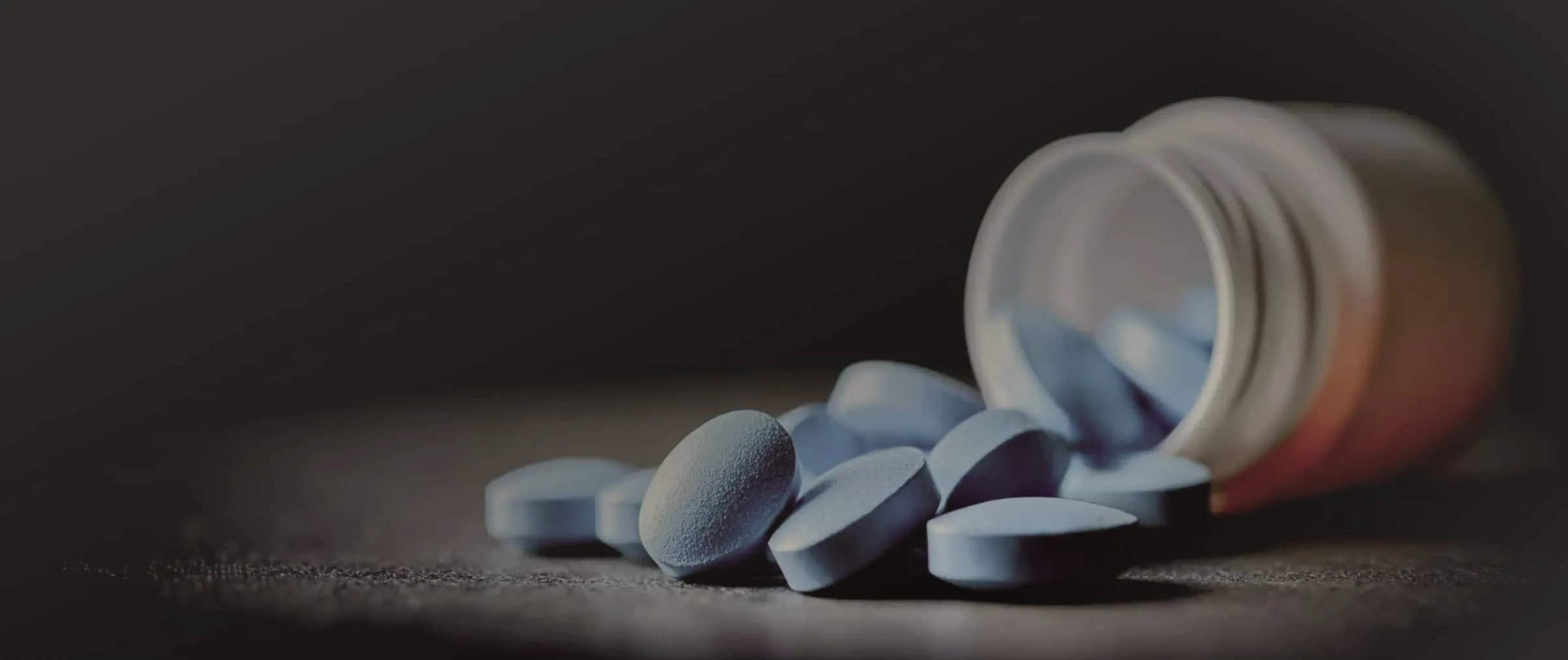 Pharmaceutical tablets beside an open medicine container