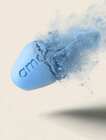 Blue pill breaking apart into powder with particles dispersing in the air.