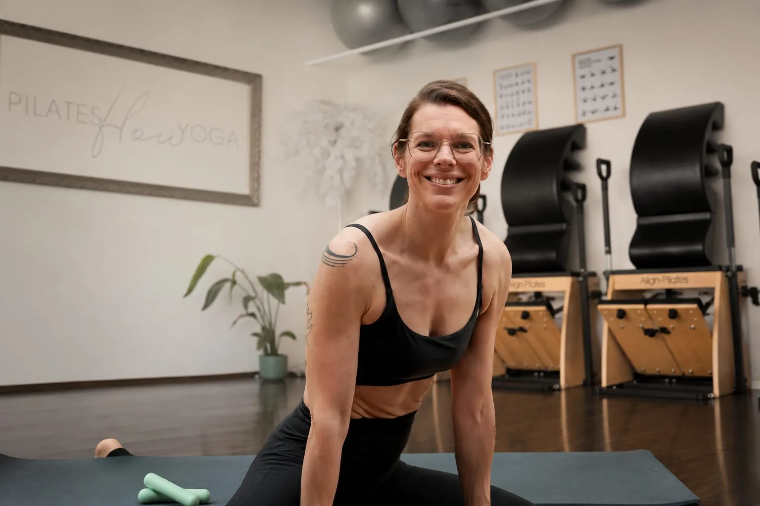 Melanie Berger lächelnd in Yogahaltung im hellen Studio, Kundenbewertung zum Website-Redesign