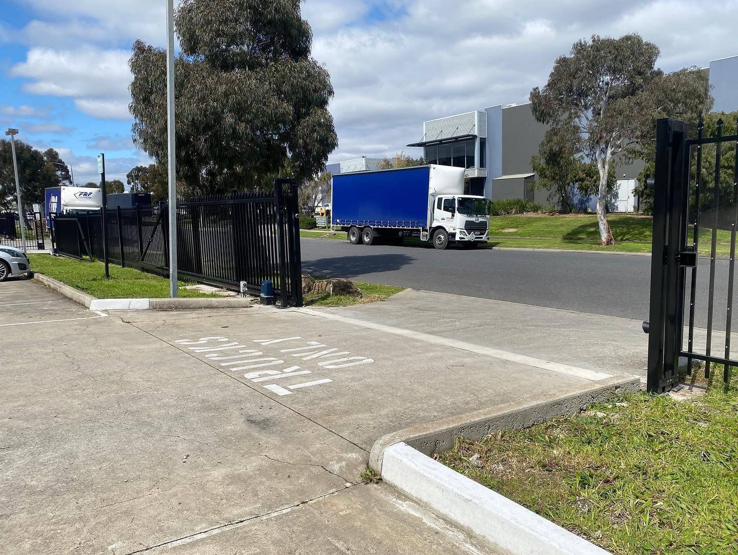 Pedestrian-access gate integrated with black spear-top security fencing