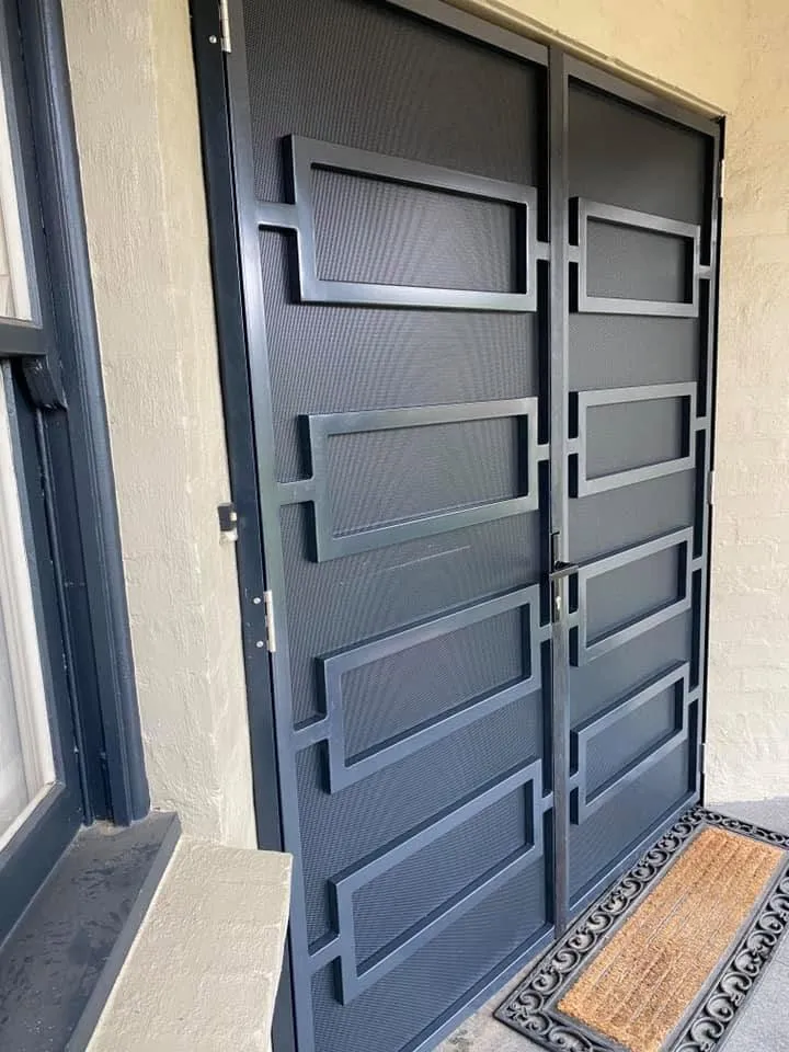 Matching double steel screen doors with geometric pattern and privacy mesh