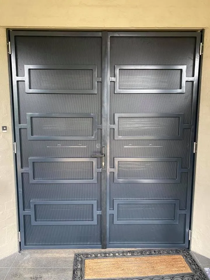 Matching double steel screen doors with geometric pattern and privacy mesh