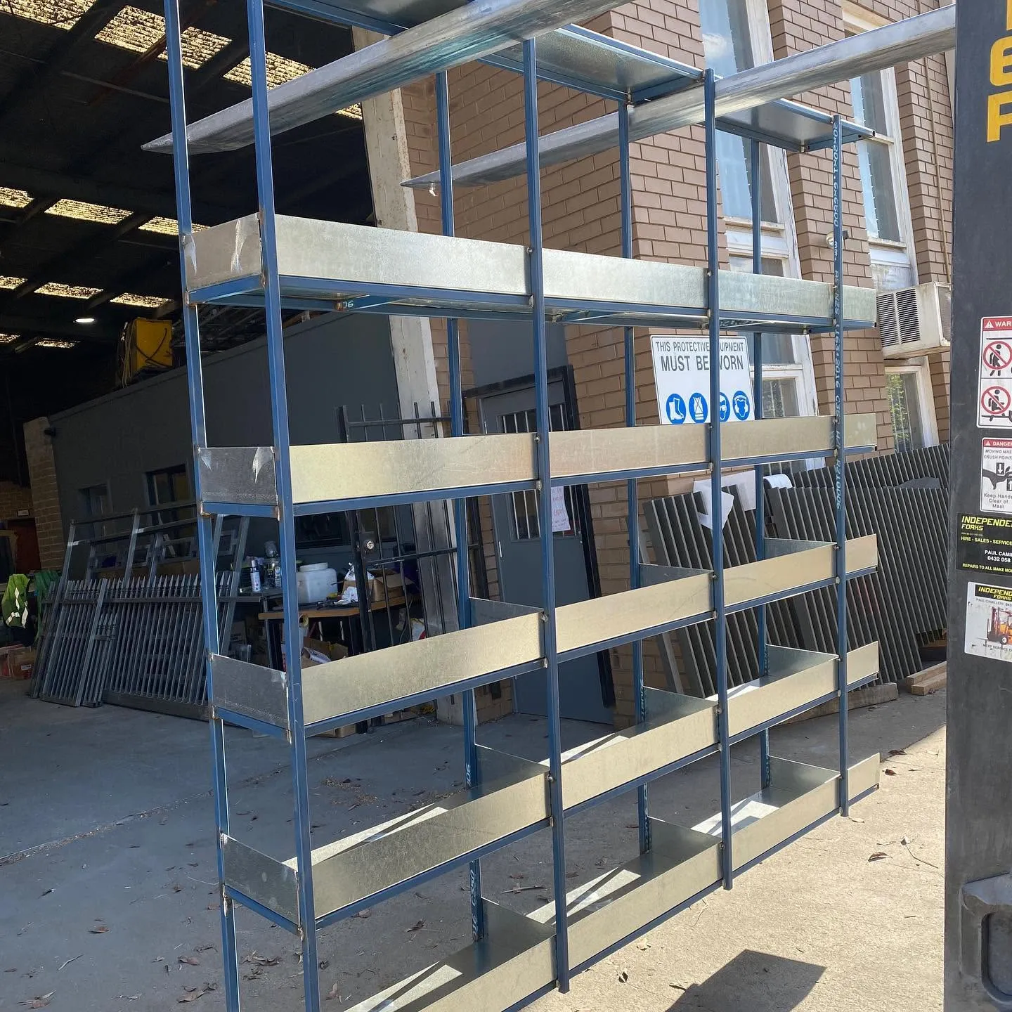 Fabricated metal frames and folded tray-style shelves in the workshop