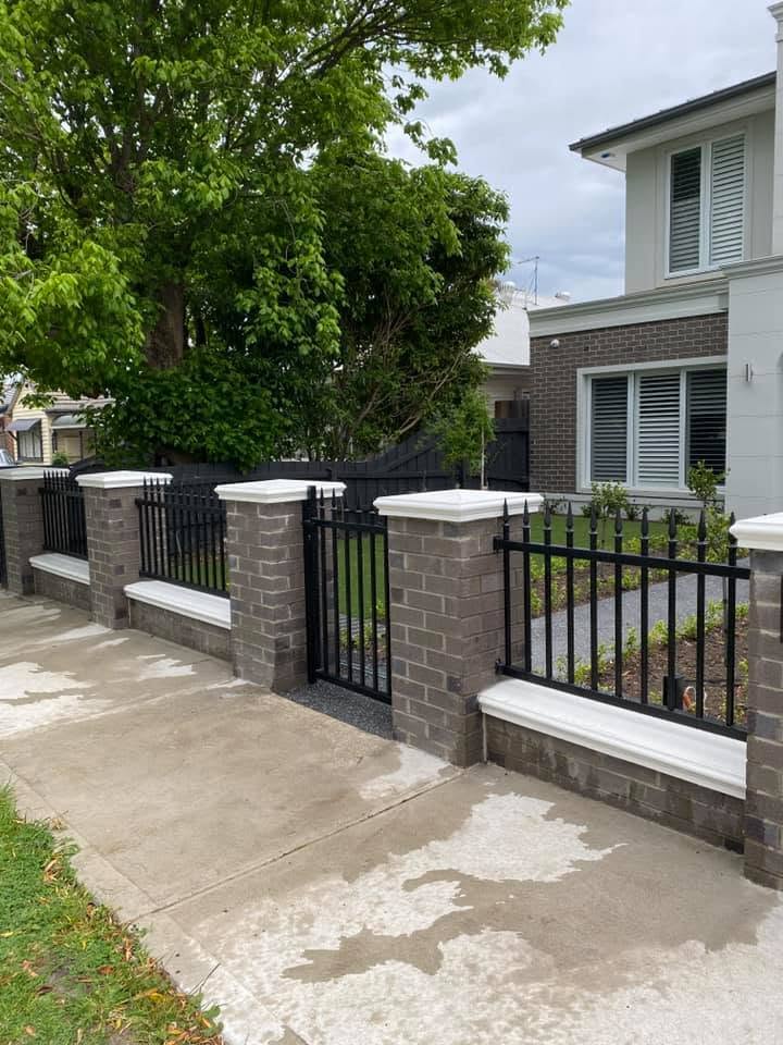 Classic black spear-top infill panels between grey brick boundary piers