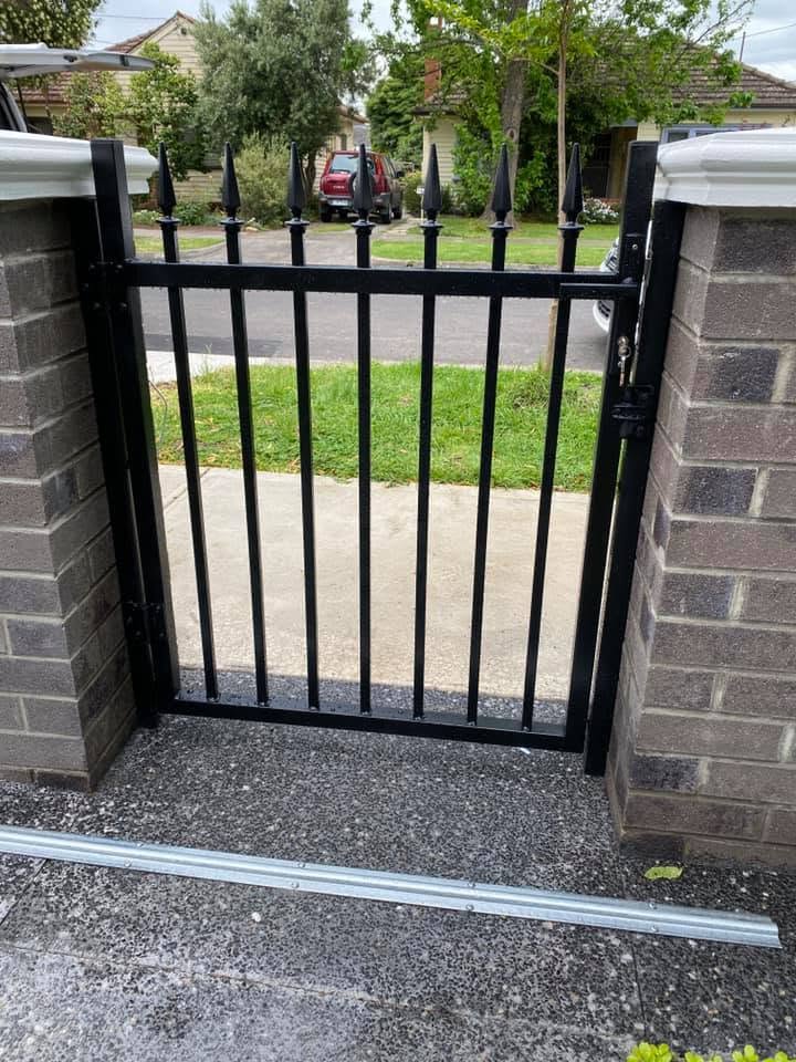 Matching pedestrian gate with spear-top pickets and black powder-coated finish