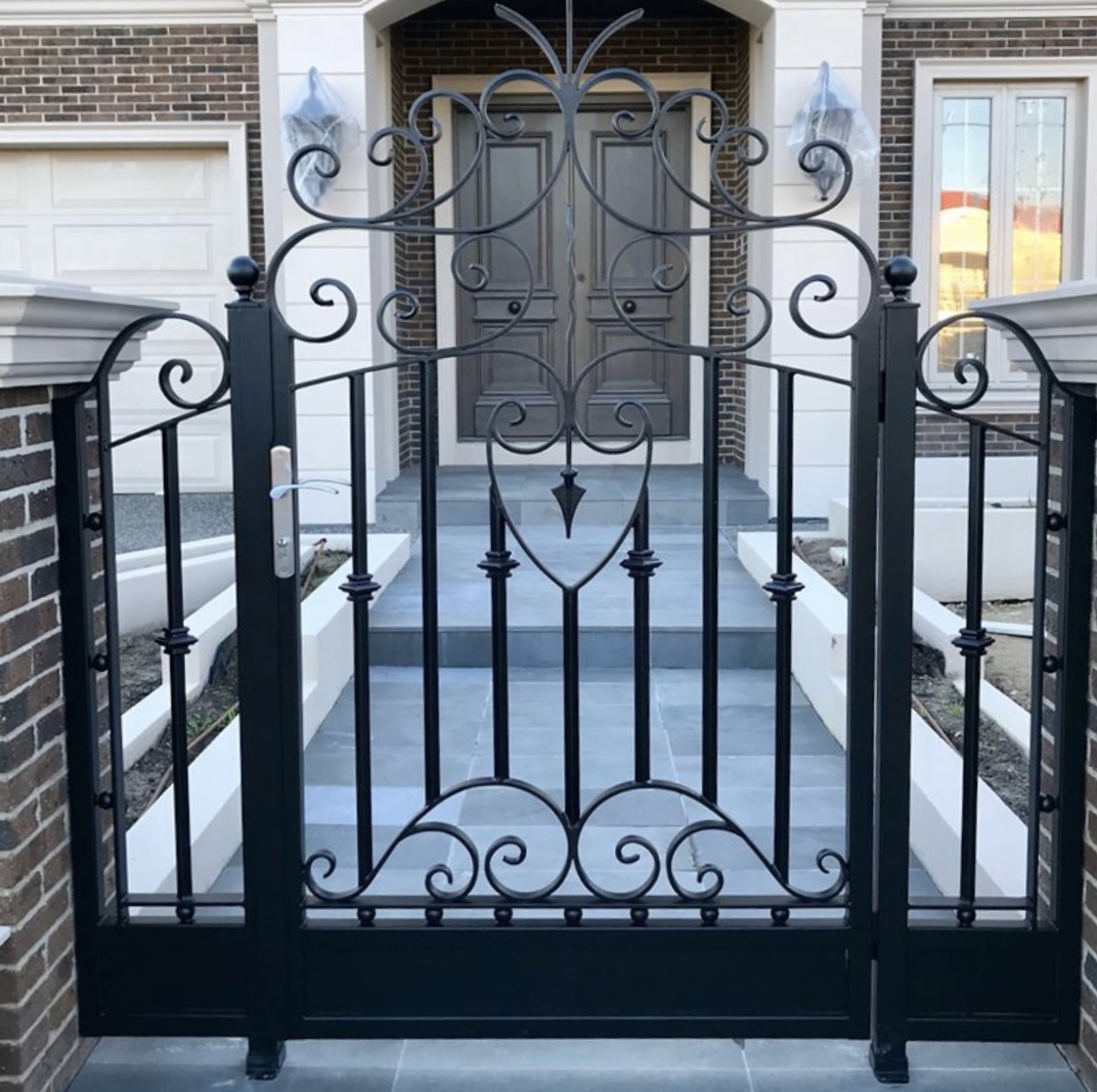 GSP Engineering Client-designed ornamental steel entry gate with decorative scrollwork and side panels