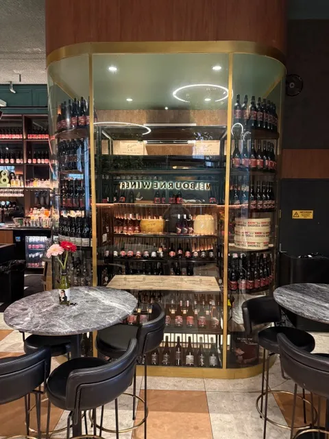 Curved glass wine-room frontage with custom bottle display shelving