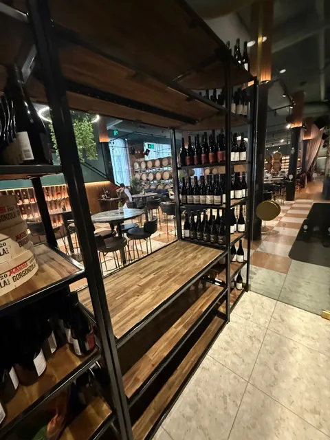 Dark metal wine-rack framing with warm timber display shelving