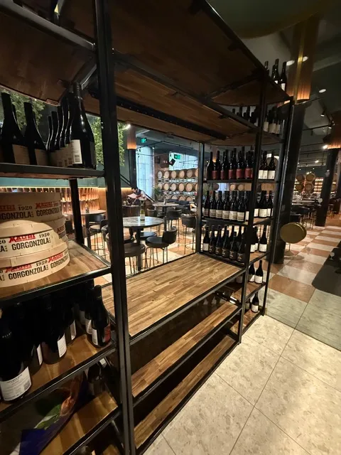Dark metal wine-rack framing with warm timber display shelving