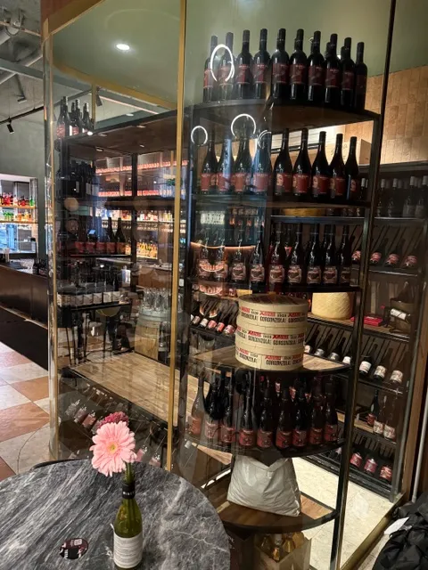 Curved glass wine-room frontage with custom bottle display shelving
