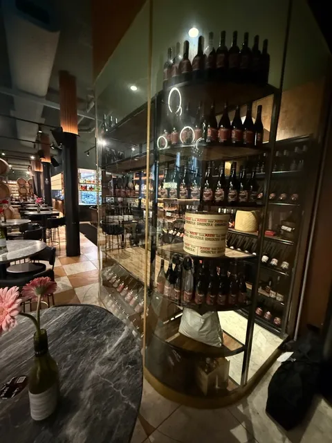 Curved glass wine-room frontage with custom bottle display shelving