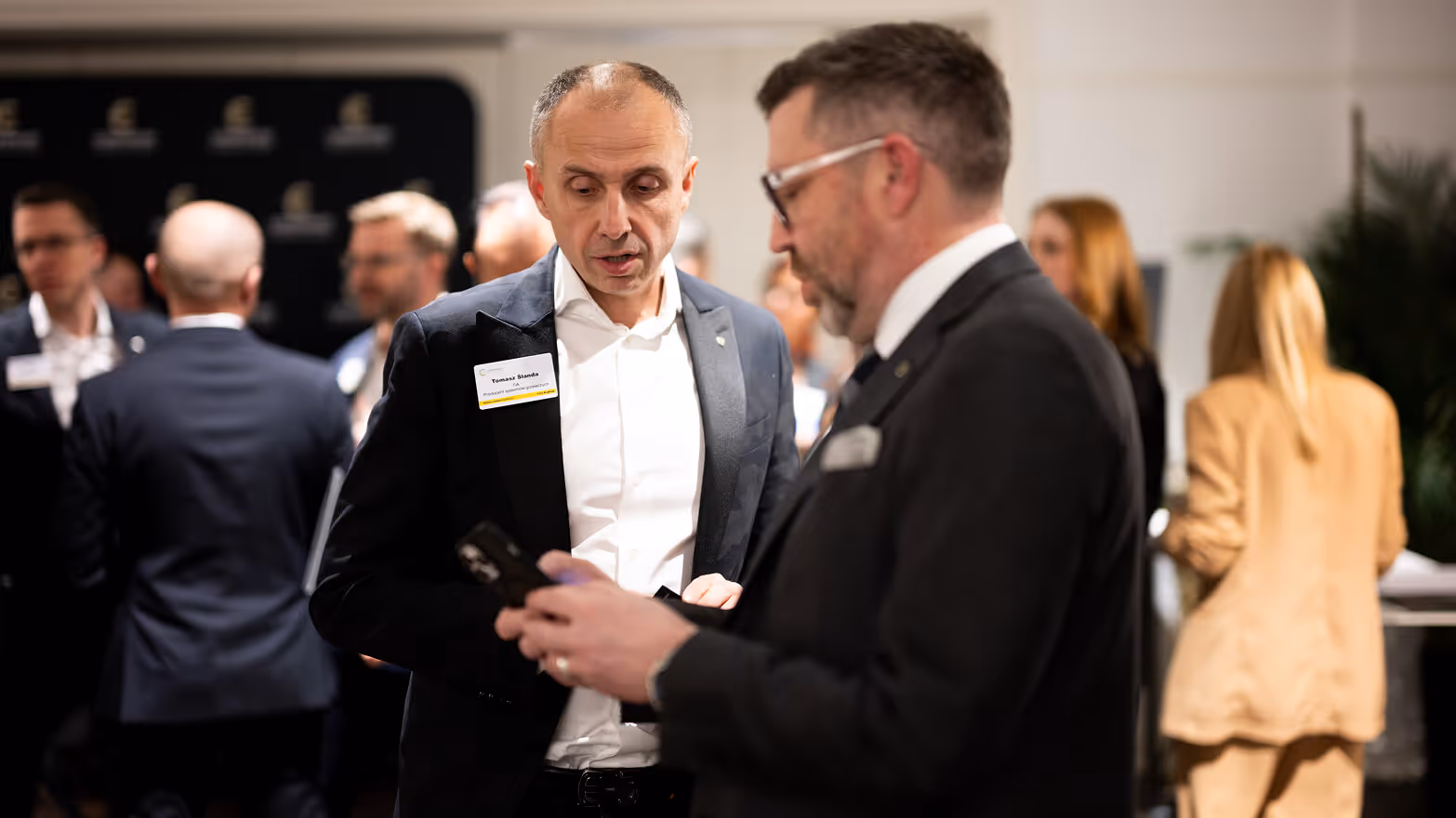 Two members wearing name badges in conversation at a CC US chapter event
