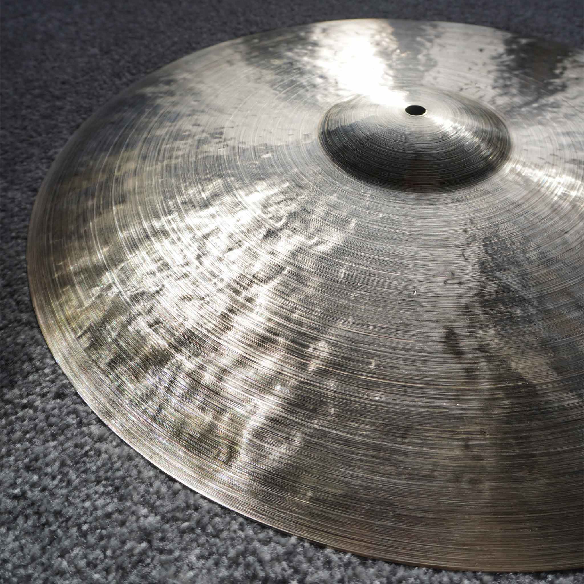 A handmade cymbal in the light showing hand-hammering and lathing