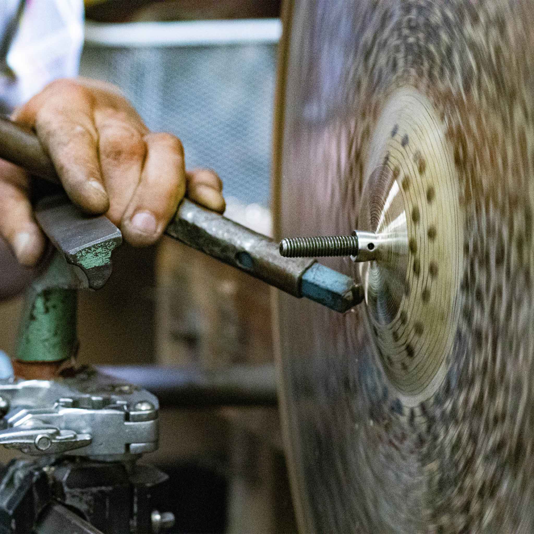 A close-up of a handmade cymbal being lathed