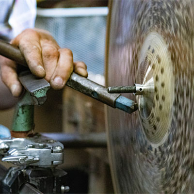 A close-up of a cymbal being lathed by hand