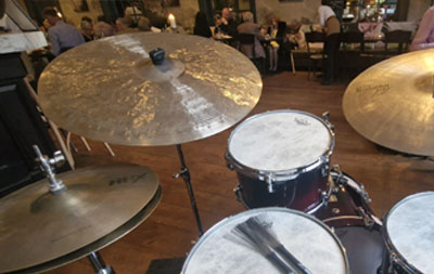 A handmade cymbal from a Make Your Own Cymbal session on a drum kit in front of an audience
