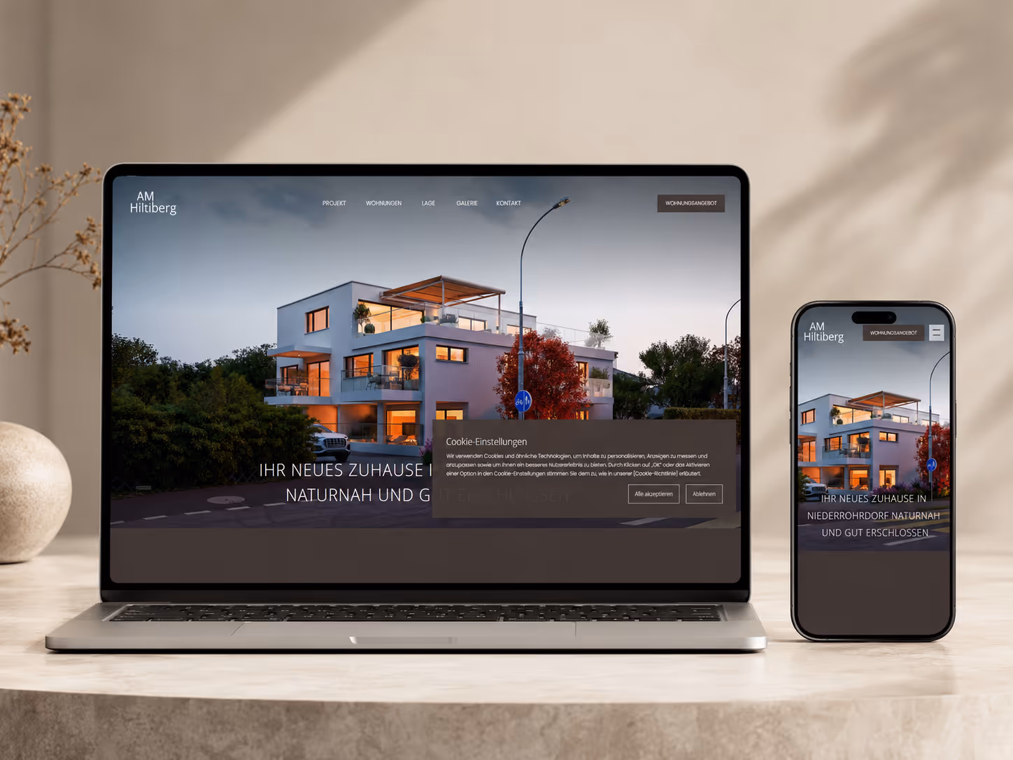 Laptop and smartphone showing a real estate site with a modern home image and German text.
