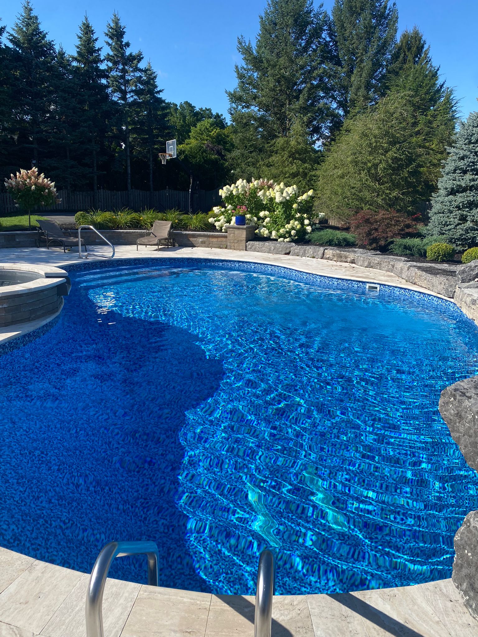 Backyard pool kept clean through weekly maintenance by Queen City Pools