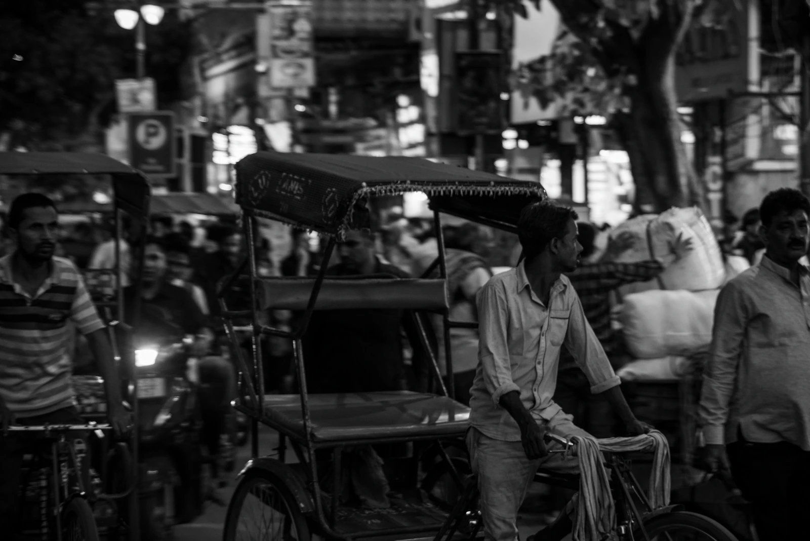 Conductor de rickshaw en una calle concurrida de Old Delhi, India