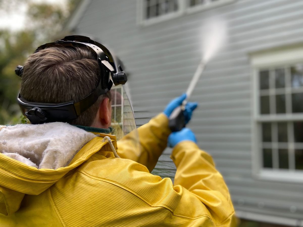 Pressure Washing — pro spraying house siding