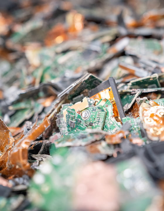 Des fragments de circuits imprimés verts étaient empilés, suggérant des déchets électroniques ou recyclage.