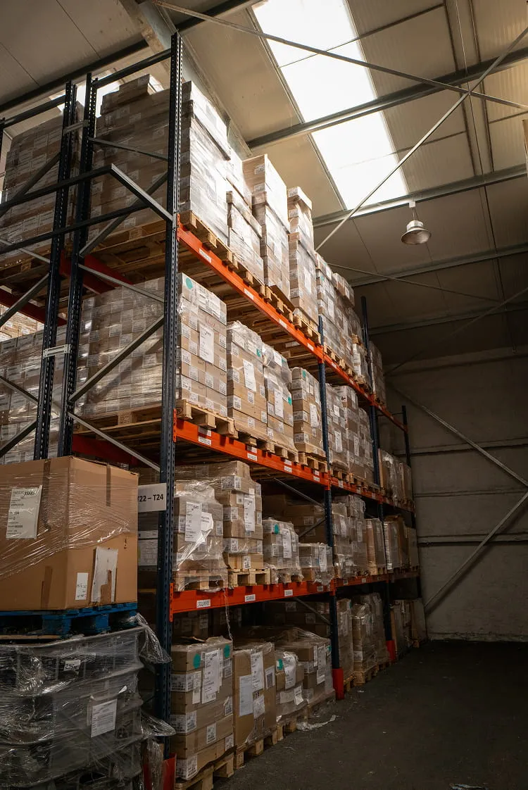 Palettes de cartons empilées sur de grands rayonnages dans un entrepôt
