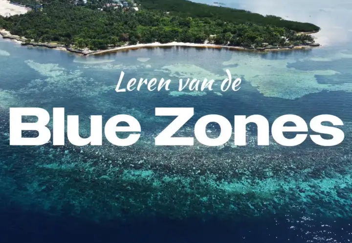 Een luchtfoto van een koraalrif en een tropisch eiland, met daarboven de tekst "Leren van de Blue Zones". Dit beeld symboliseert de gedeelde geheimen van een lang en gezond leven die worden onderzocht tijdens de vergelijkende reis naar Japan en Sardinië.