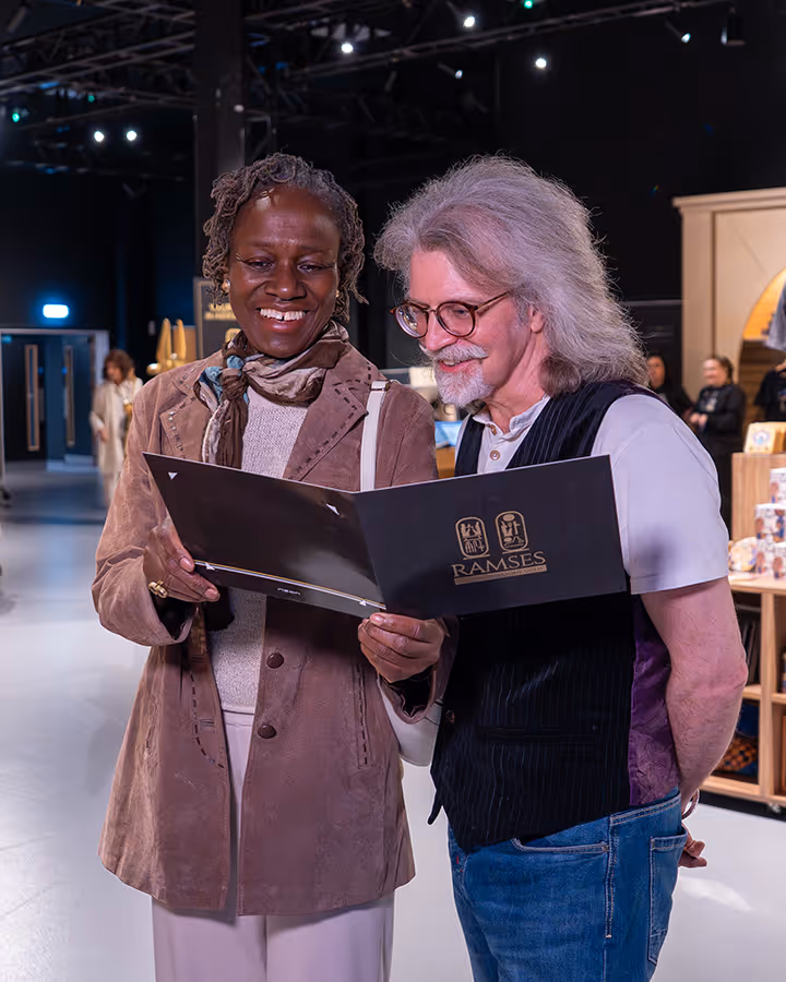 Smiling man and woman reviewing a photo taken from their experience.