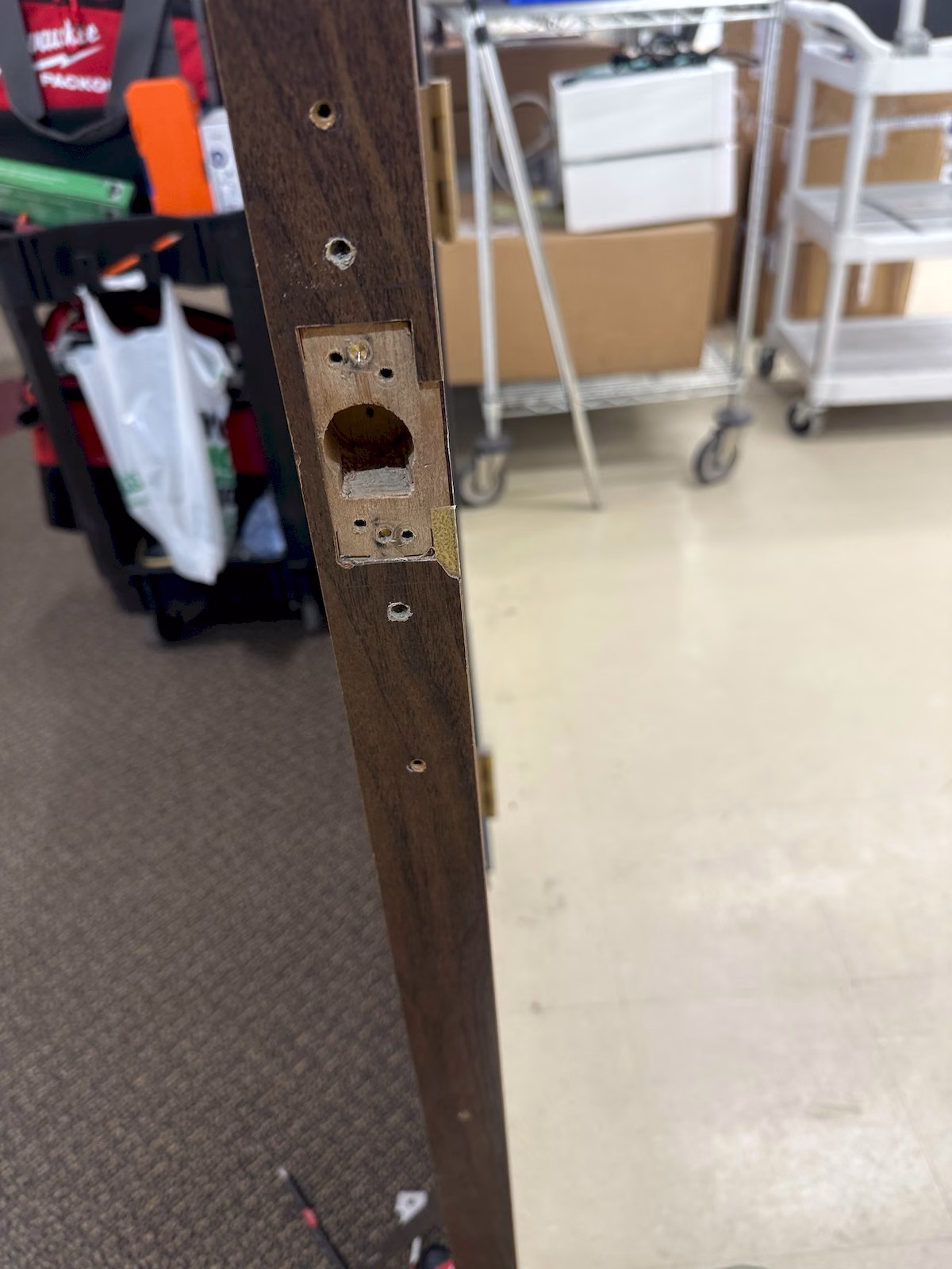 Existing lock hardware pocket exposed during preparation for an electric strike installation.
