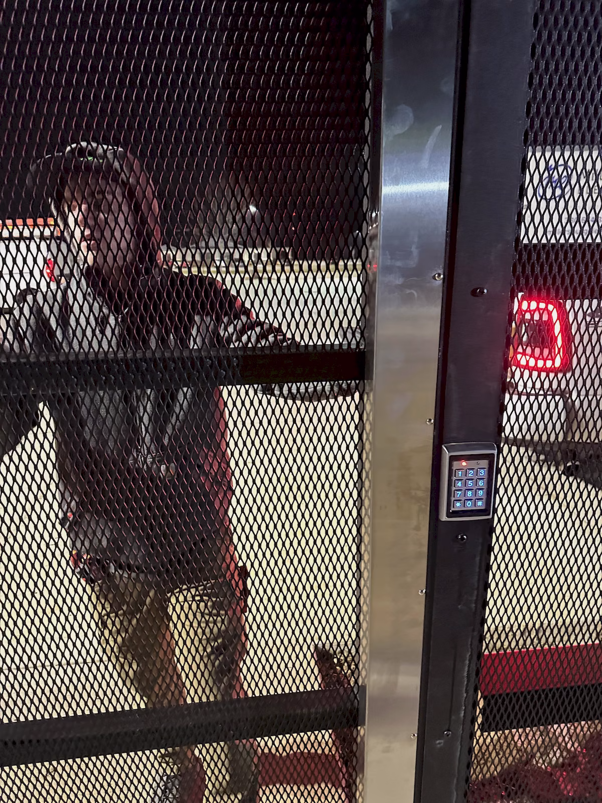 Technician testing the illuminated keypad on an exterior access-controlled security gate.