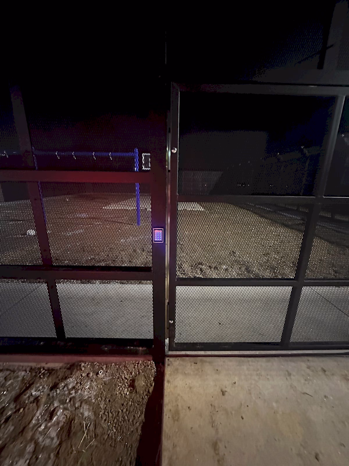 Full view of an exterior pedestrian gate secured with a vertical full-length magnetic lock and keypad.