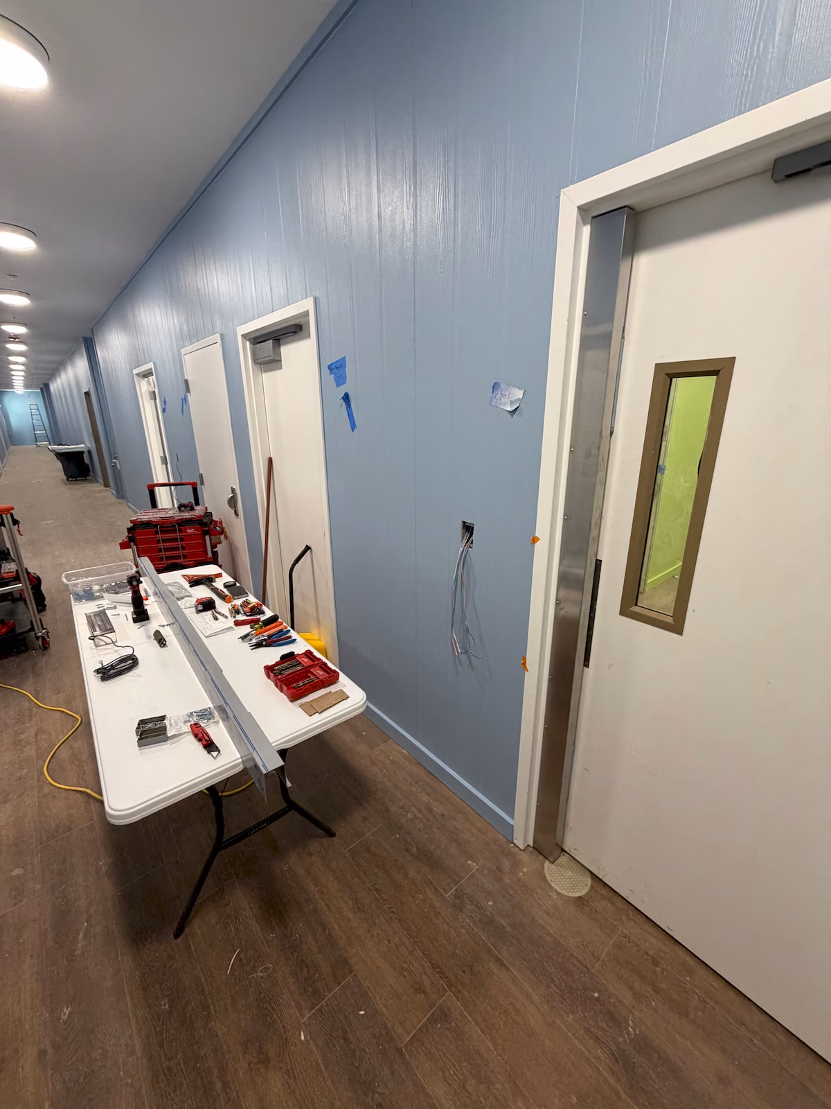 Commercial hallway door equipped with full-length electromagnetic access control hardware.