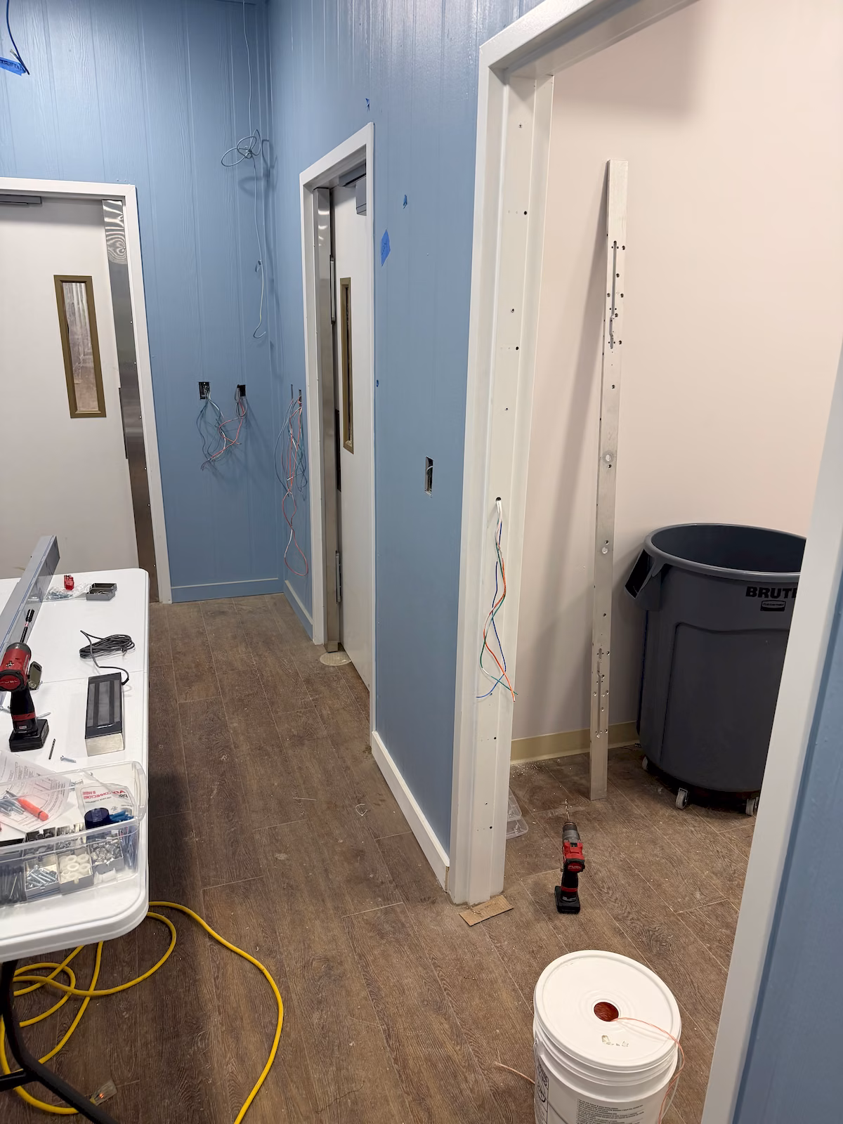 Interior doorway and wiring being prepared for a full-length electromagnetic lock installation.
