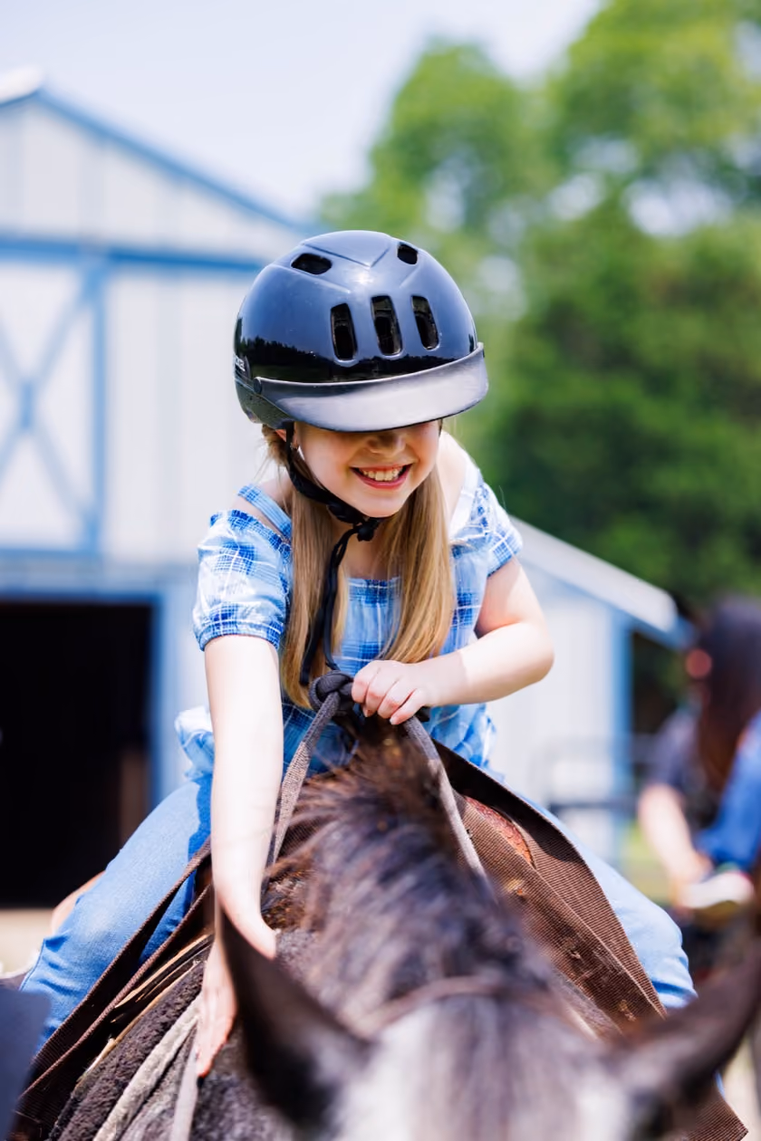 Young rider smiling on a horse at Kay's Acres