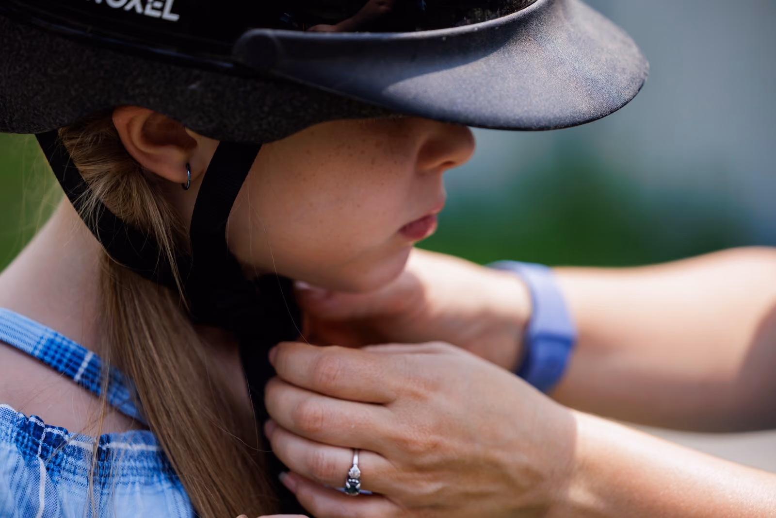 Rider adjusting helmet chin strap
