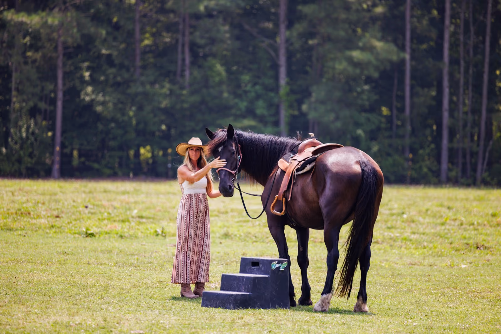 Woman with horse in grassy field