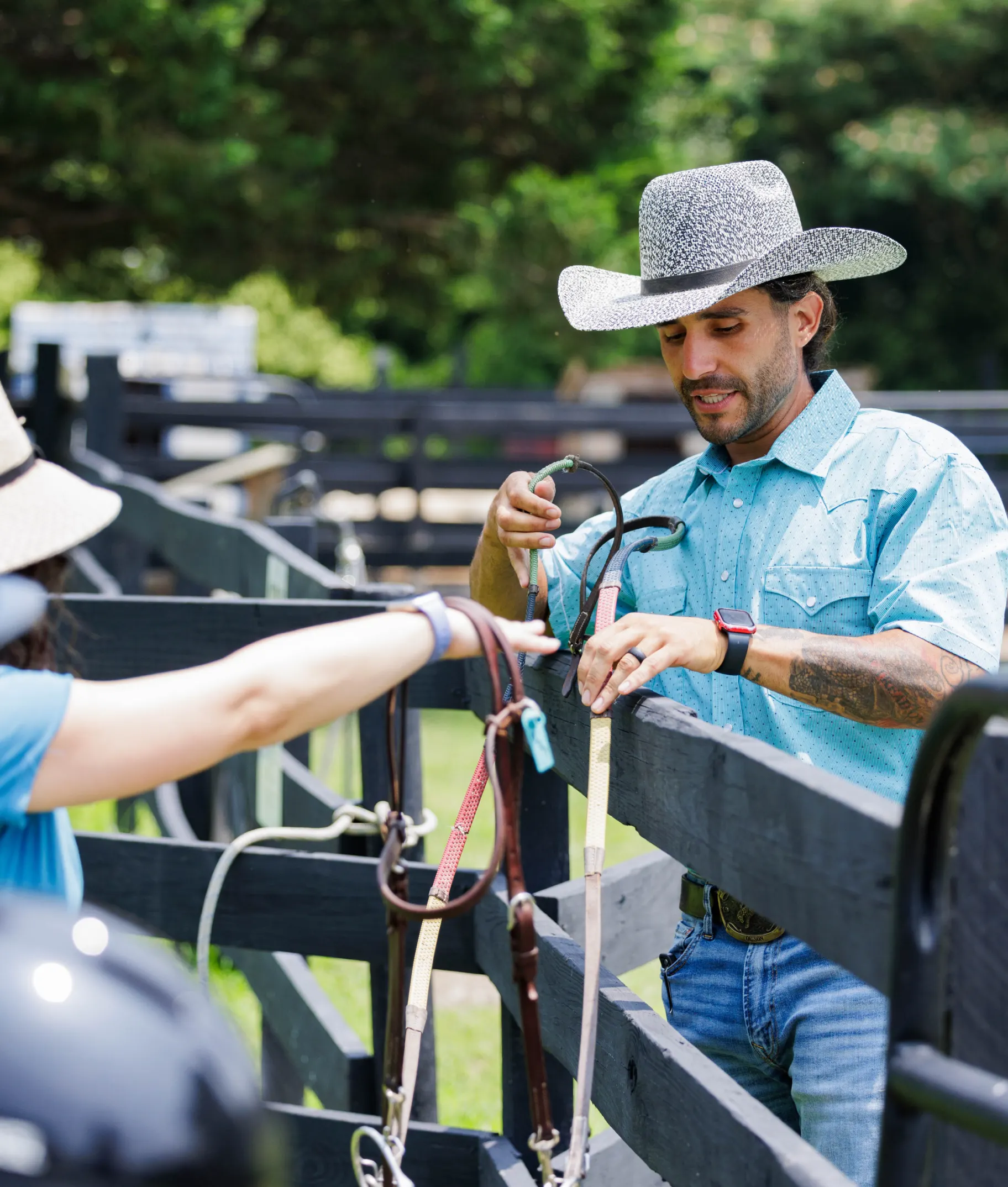 Team member adjusting horse tack at Kay's Acres