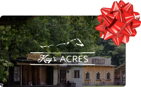 Kay's Acres gift card with the ranch logo over Western Frontier Town storefronts and a red gift bow.