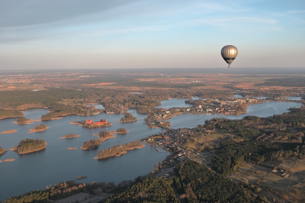 a hot air balloon flying over a large body of water
