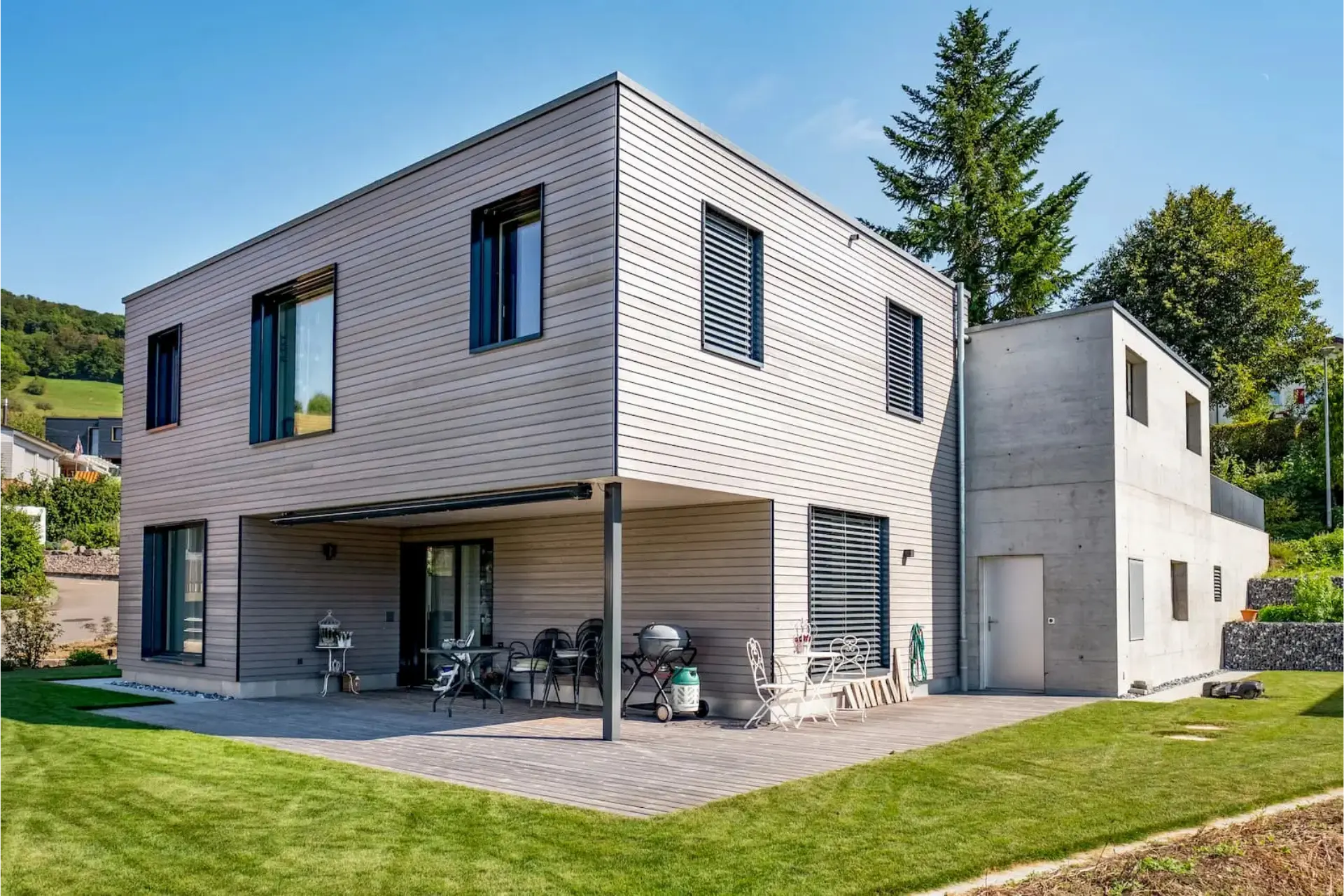 Einfamilienhaus Gansingen – Holzfassade und Terrasse mit Ausblick in die Landschaft