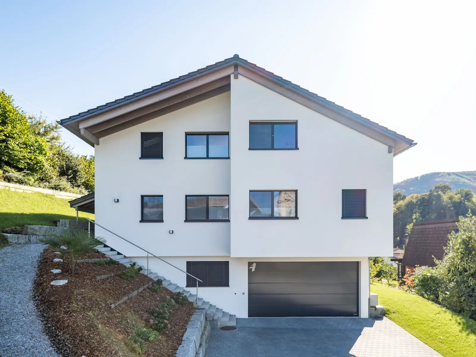 Strassenseitige Ansicht des Einfamilienhauses in Sulz mit Einliegergarage und verputzter Fassade