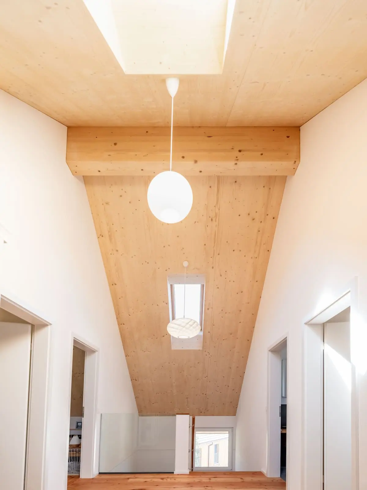 Oberer Geschossbereich mit sichtbarer Holzkonstruktion, Dachfenster und offener Raumhöhe im Einfamilienhaus Mandach.
