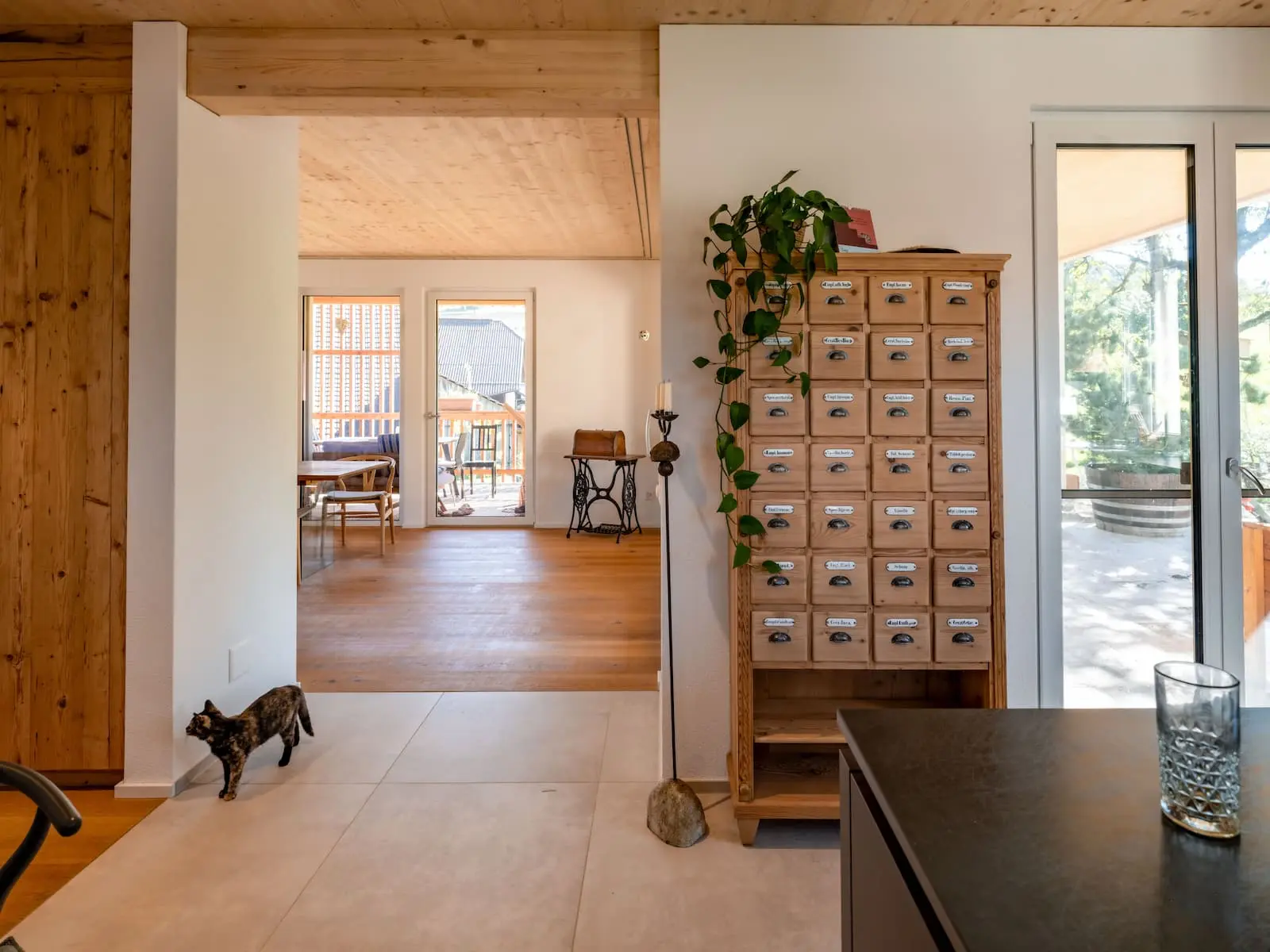 Innenraum mit sichtbarer Holzdecke und Blick durch offen gestaltete Wohnräume im Einfamilienhaus Mandach.