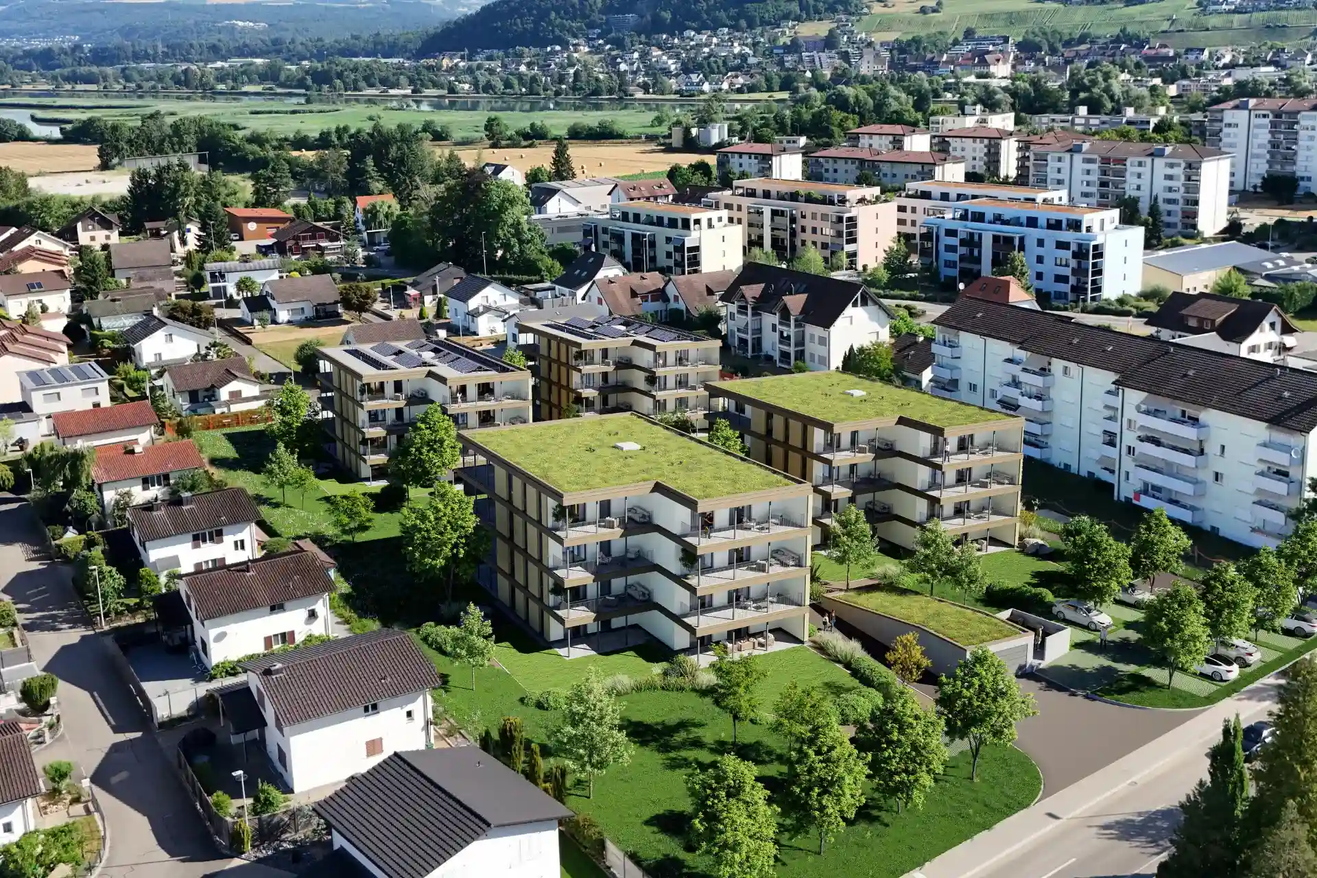 Luftaufnahme der Wohnüberbauung Kleindöttingen mit vier viergeschossigen Mehrfamilienhäusern, begrünten Flachdächern und Blick über das Aaretal.