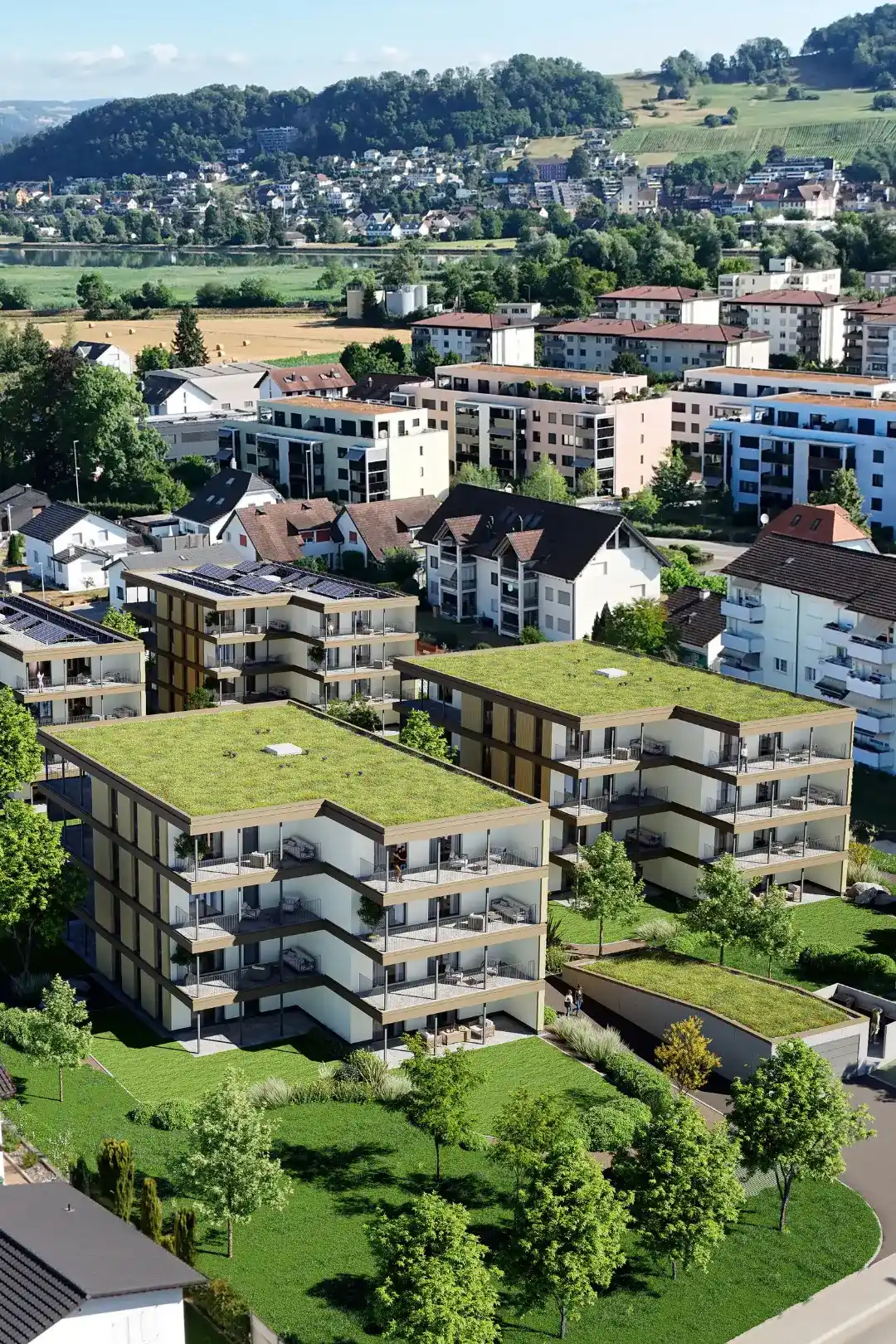 Luftaufnahme der Wohnüberbauung Kleindöttingen mit vier viergeschossigen Mehrfamilienhäusern, begrünten Flachdächern und Blick über das Aaretal.